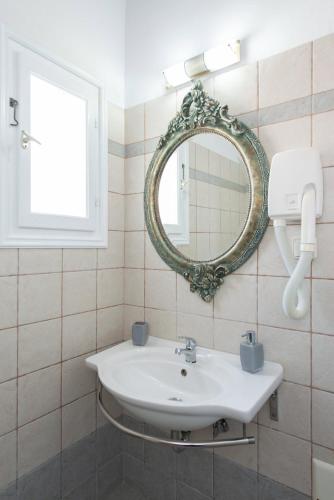 a bathroom with a sink and a mirror at Studios Poulati in Artemonas