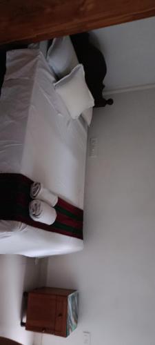 a bunk bed with white sheets and pillows on it at Casa Branca in Siolim