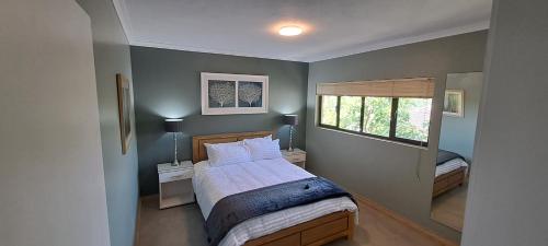 a bedroom with a bed with two night stands and a window at Executive Flat with Stunning Views in Westville