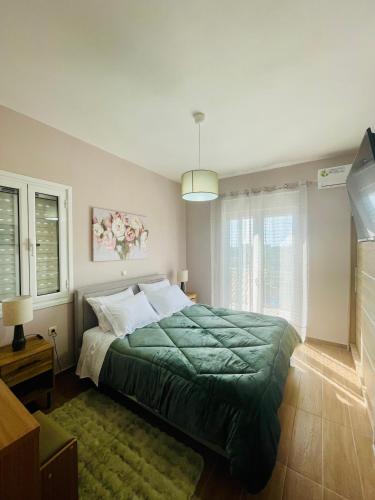 a bedroom with a green bed and a window at Stella Collection in Kranidi