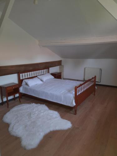 a bedroom with a bed and a white rug at Maison Vacances in Saint-Savinien