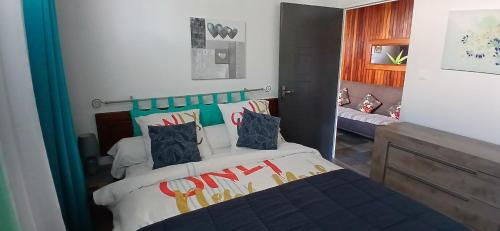 a bedroom with a large bed with colorful pillows at Le Papyrus in Cilaos