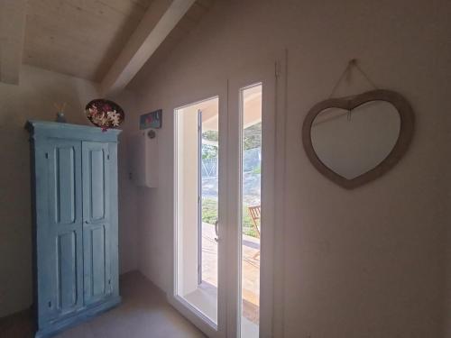 ein Zimmer mit einem herzförmigen Spiegel an der Wand und einer Tür in der Unterkunft B&bo in Pesaro