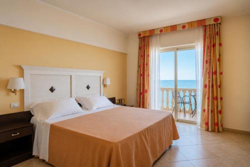 a bedroom with a bed with a view of the ocean at Hotel Orizzonte in Letojanni