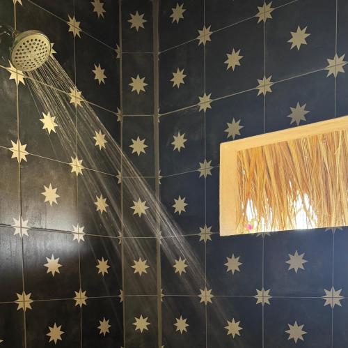 a blue tiled wall with stars and a mirror at Banana Tree Popoyo in Popoyo
