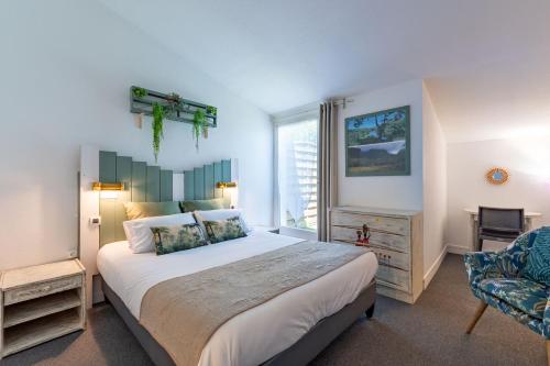 a bedroom with a large bed and a window at Hôtel Le Parasol in Ars-en-Ré