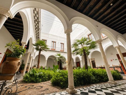a building with palm trees and a glass ceiling at Mercer Residences Sevilla in Seville