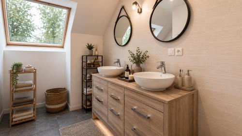 a bathroom with two sinks and two mirrors at Villa Confidentielle Opale in Merlimont