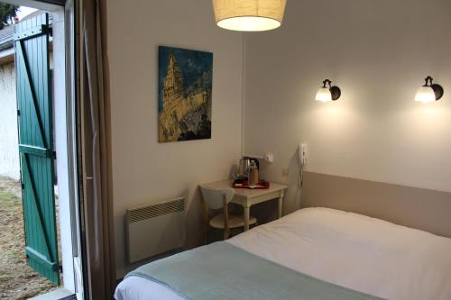 a bedroom with a bed and a table and a window at Villa Hotel in Troyes
