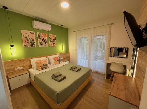 a bedroom with a bed with a green wall at Abigails Pool House in Kallirákhi