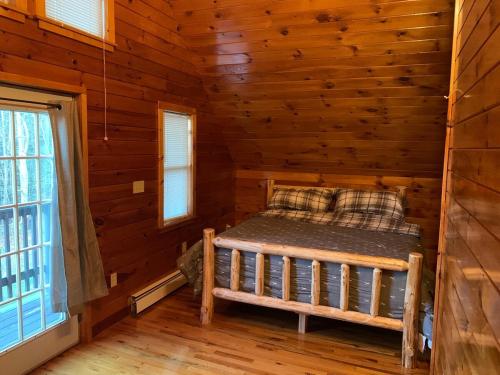 a bedroom with a bed in a log cabin at Private with a Beautiful View House in Afton