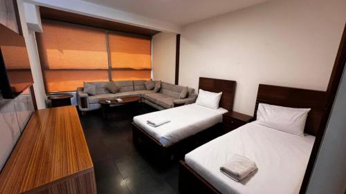 ein Hotelzimmer mit zwei Betten und einer Couch in der Unterkunft Le Marly Hotel in Beirut