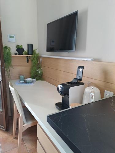 a table with a coffee maker and a television on a wall at Studio sisco in Sisco