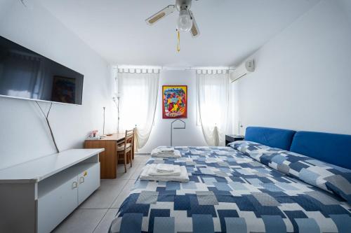 a bedroom with a blue bed and a desk at B&B We CaRe Appartamento in Lendinara