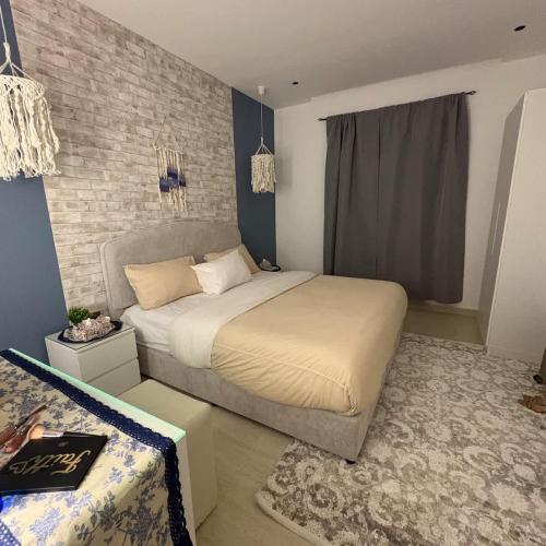 a bedroom with a bed and a brick wall at Greek Home4 in Al Khobar