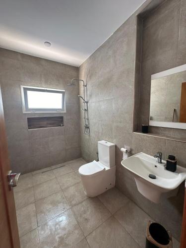 a bathroom with a white toilet and a sink at Diar Jabal Villa S2 in Banī ‘Aţāʼ