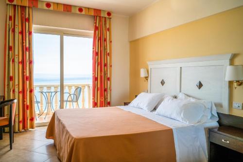 a bedroom with a bed with a view of the ocean at Hotel Orizzonte in Letojanni