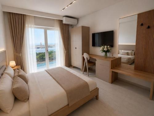 a bedroom with a bed and a desk and a television at Marevento Hotel in Costinesti