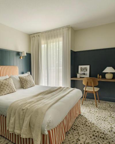 a bedroom with a large bed and a window at Domaine Golf Saint-Lazare in Limoges