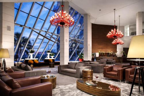 a lobby with couches and chairs and large windows at Antony Palace Hotel - Venice Airport in Marcon