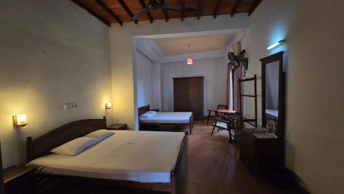 a bedroom with a bed and a desk in a room at Melvila in Colombo