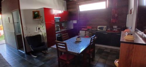 a kitchen with a table with chairs and a kitchen with a counter at Le Papyrus in Cilaos