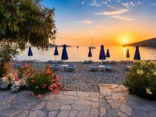 a group of umbrellas and chairs in front of the water at Dream Island Hotel in Livadia