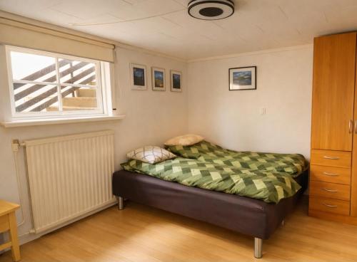a bedroom with a bed and a window at Cozy apartment in Klaksvík