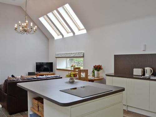 a kitchen and living room with a large island in the middle at Longcroft Dairy in Oyne