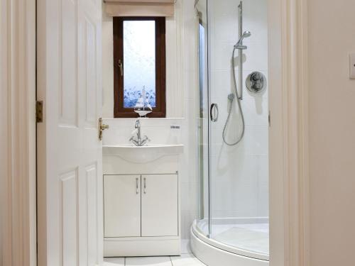a white bathroom with a sink and a shower at Sycamore Lodge in Sewerby