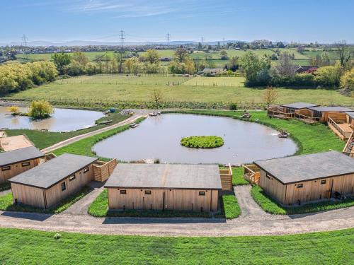 an aerial view of a farm with a pond and buildings at Mandarin Lodge - Uk51936 in Yarm