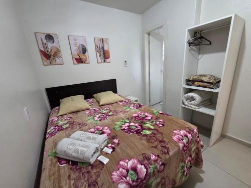 a bedroom with a bed with flowers on it at Hotel Três Passos - Prox ao Aeroporto e Rodoviária in Porto Alegre