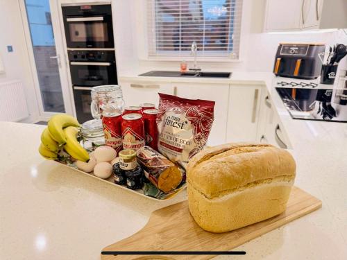a loaf of bread sitting on a cutting board next to a sandwich at Royal Border Retreat in Berwick-Upon-Tweed
