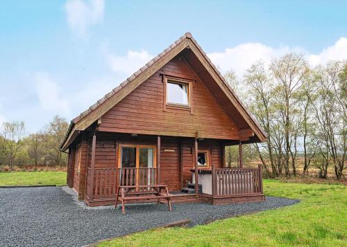 a log cabin with a bench in front of it at Benview Holiday Lodges in Gartmore