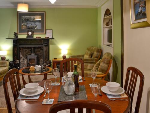 a dining room with a table and a fireplace at Boatmans Cottage - 27787 in Portessie