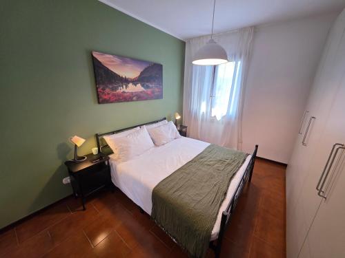 a bedroom with a large bed in a green wall at La Tana - Borno Holiday in Borno