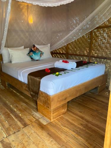 a bed in a room with flowers on it at Bayan Exotic Homestay in Senaru