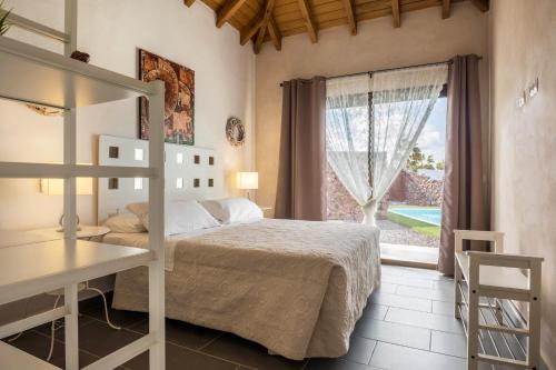a bedroom with a bed and a desk and a window at Villa La Era 1 in El Cotillo