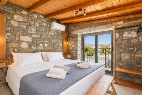 a bedroom with a large bed with towels on it at La Casa Di Pietre 1 in Kiotari