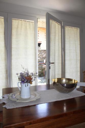a table with a bowl and a vase of flowers at Agriturismo Abbonbri in Quarrata