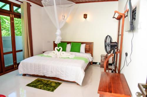 a bedroom with a bed with green and white sheets at Zenora Villa ella in Ella