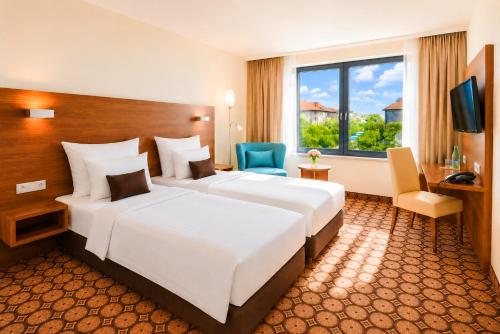a hotel room with two beds and a television at CZECH INN Hotel Ferenc in Budapest