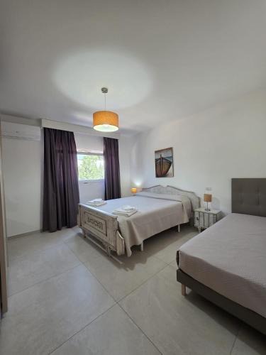 a large bedroom with two beds and a window at Villetta Lu Sule in Porto Cesareo