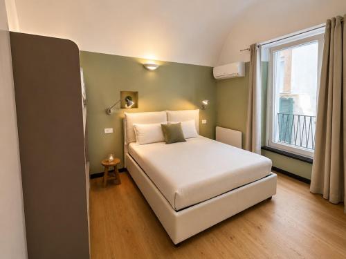 a bedroom with a white bed and a window at Cà di Righe in Pietra Ligure