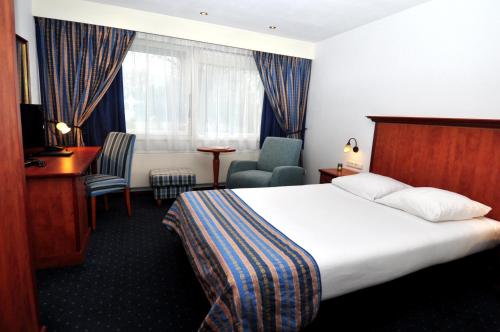 a hotel room with a bed and a desk and chair at Boutique Hotel Herbergh Amsterdam Airport FREE PARKING in Badhoevedorp