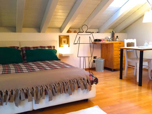 a bedroom with a bed and a table and a dresser at La Mansarda di Margherita in Treviso