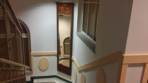 a hallway with a mirror and a stairway at Art Deco WOLKER by ASTORIA Hotel & Medical Spa in Karlovy Vary