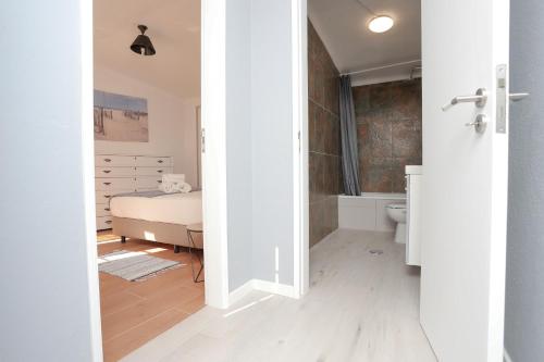a bedroom with a bed and a bathroom at Villa Bocage in Setúbal