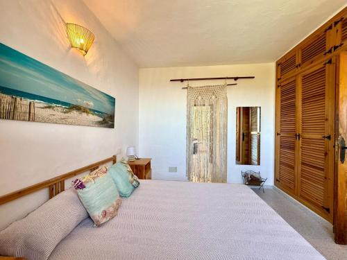 a bedroom with a large bed with blue pillows at Villa Sa Guaita in Sant Josep de sa Talaia