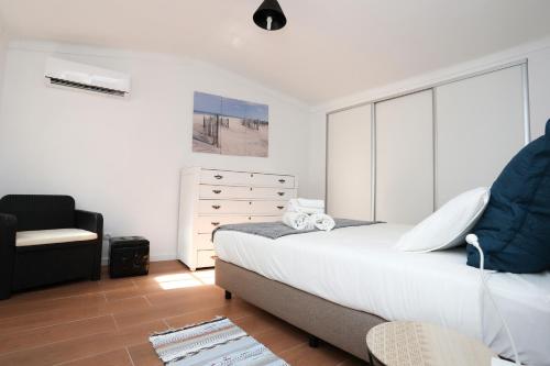 a bedroom with a bed and a chair and a dresser at Villa Bocage in Setúbal